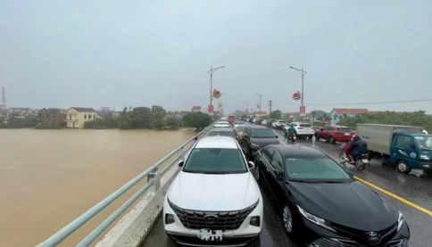Thương lắm miền Trung: Mưa như trút, chủ động phá dỡ đê quai, người dân đưa ô tô lên cầu tránh lũ