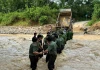Hàng rào công an che chắn cho sản phụ vượt dòng nước xiết