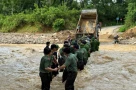 Hàng rào công an che chắn cho sản phụ vượt dòng nước xiết