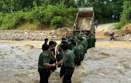 Hàng rào công an che chắn cho sản phụ vượt dòng nước xiết