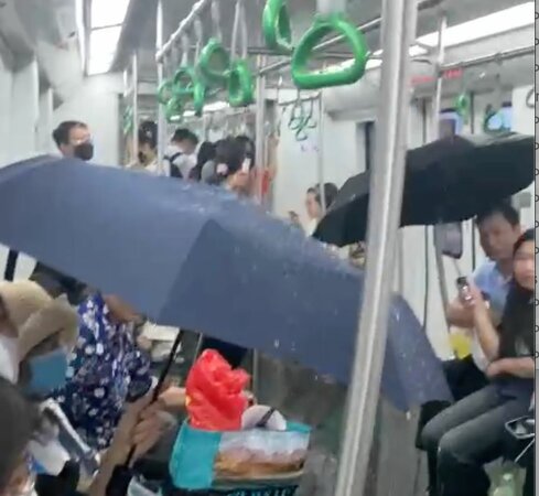 Khách đi tàu Cát Linh- Hà Đông che dù vì nước trên trần nhỏ tong tong xuống đầu😆 Chỉ là