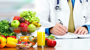 A doctor writing on a notepad with a bowl of fruitDescription automatically generated